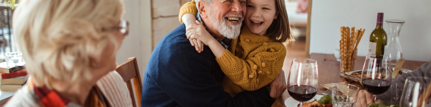 An image of an old man laughing with his grand-daughter.